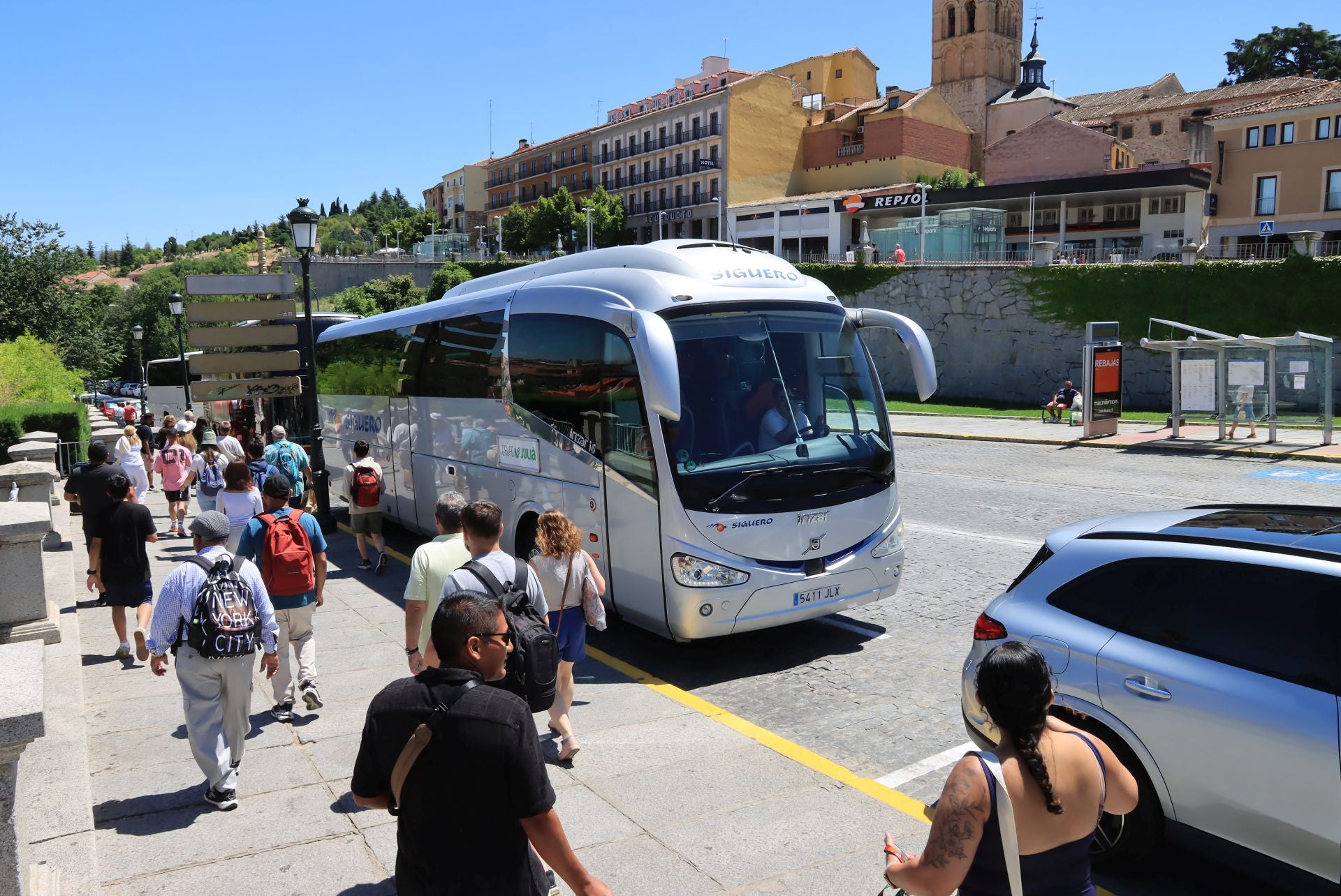 Personas pasean por Vía Roma junto a varios autobuses turísticos.