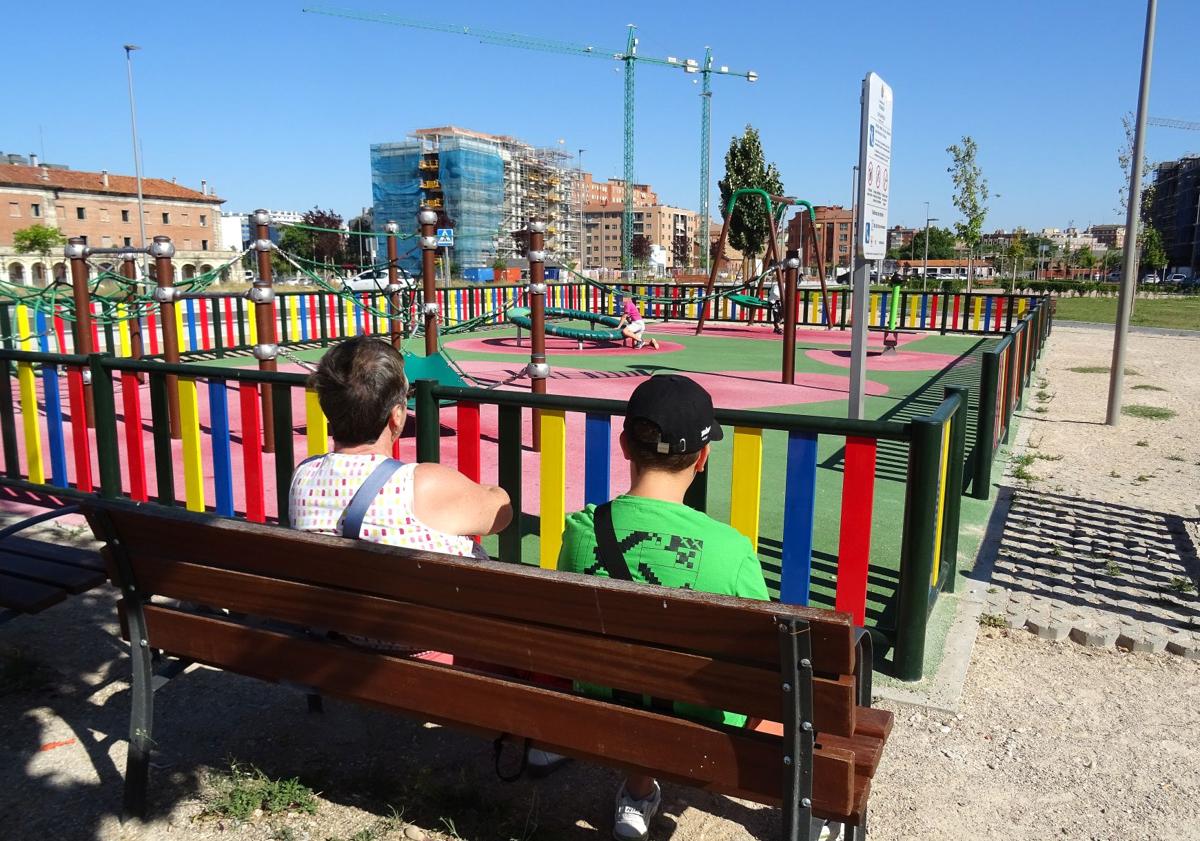 Imagen principal - Arriba, una vecina de Delicias, junto a su nieto, vigila a otro nieto de menor edad en el parque central de los terrenos de Artillería. Debajo, a la izquierda, el bloque en rehabilitación del lado del cuartel Conde Ansúrez que ocupará la Escuela Superior de Diseño. A la derecha, el primer edificio habitado del barrio (el residencial Artillería I).