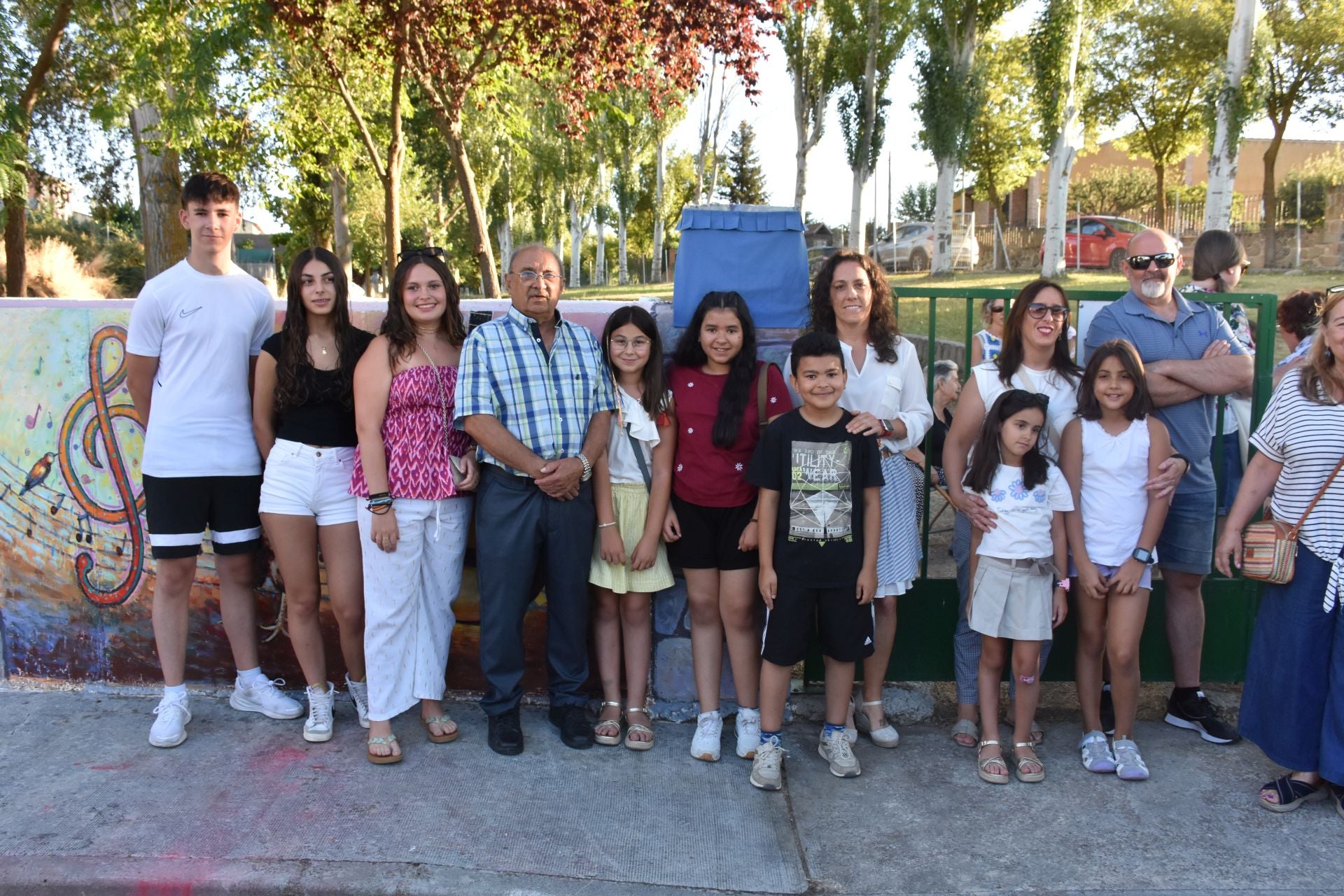 Ángel Pérez Dimas posa frente a los murales junto con sus alumnos, la alcaldesa y algunos vecios de Zarzuela del Monte.
