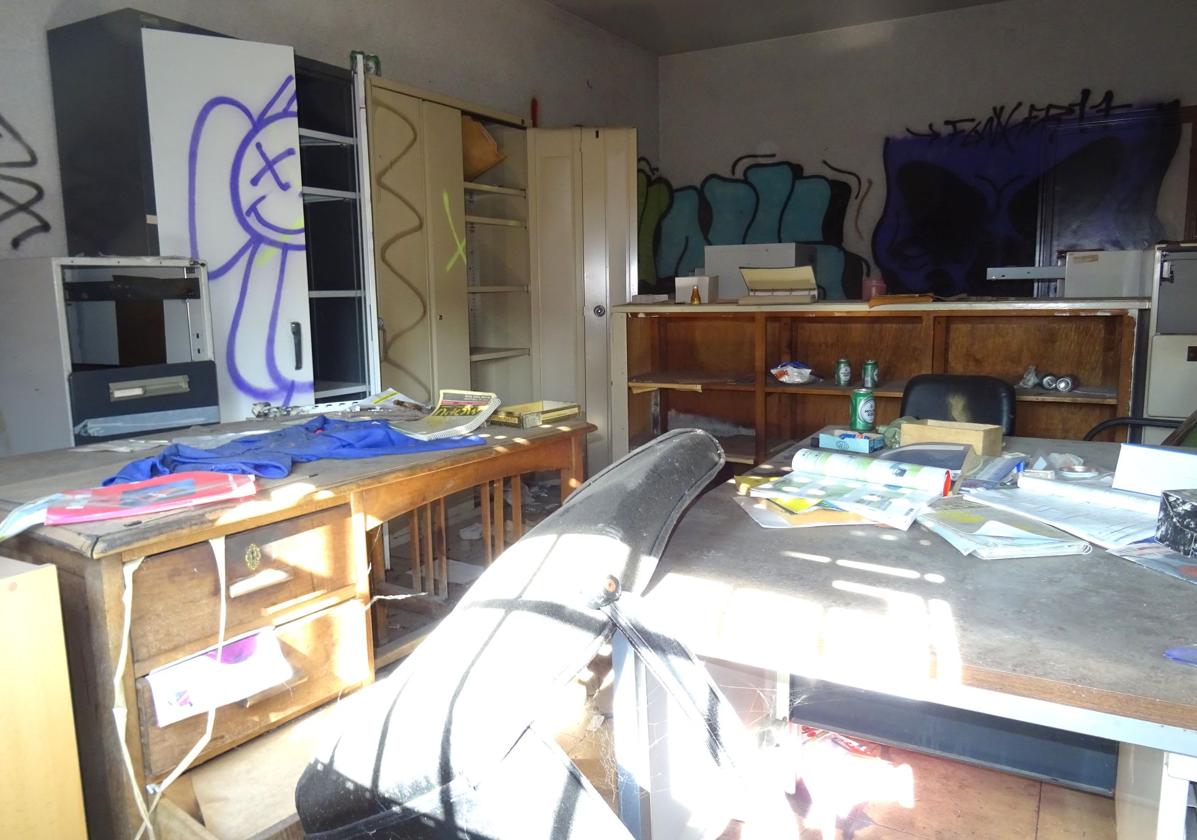 Interior de una de las oficinas del interior del recinto, con pintadas en su paredes.