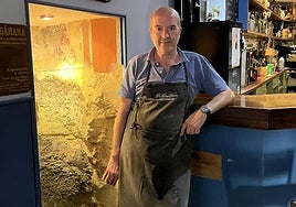 Luis Fernando Andrés, junto a la vitrina que deja ver la histórica arqueta, en el interior del bar.