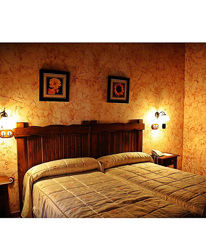 Imagen secundaria 2 - Pluma con verduras, plato estrella del establecimiento. Uno de los rincones del restaurante y una de las habitaciones de la posada.