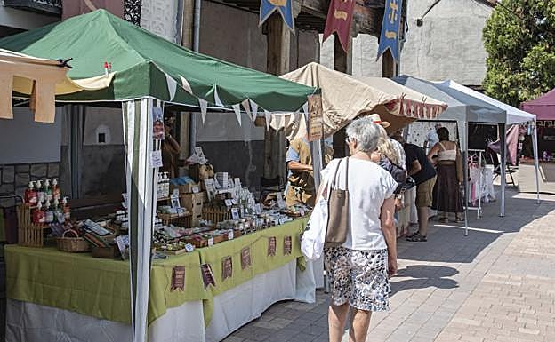 Visitantes recorren algunos de los puestos del mercado de artesanía en Aguilafuente.