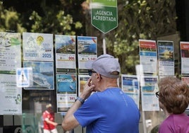 Dos personas consultan los viajes anunciados en la agencia de El Corte Inglés de Palencia.