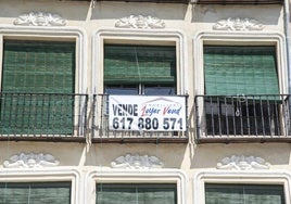 Cartel de 'se vende' colocado en el balcón de una vivienda del casco histórico de Segovia.