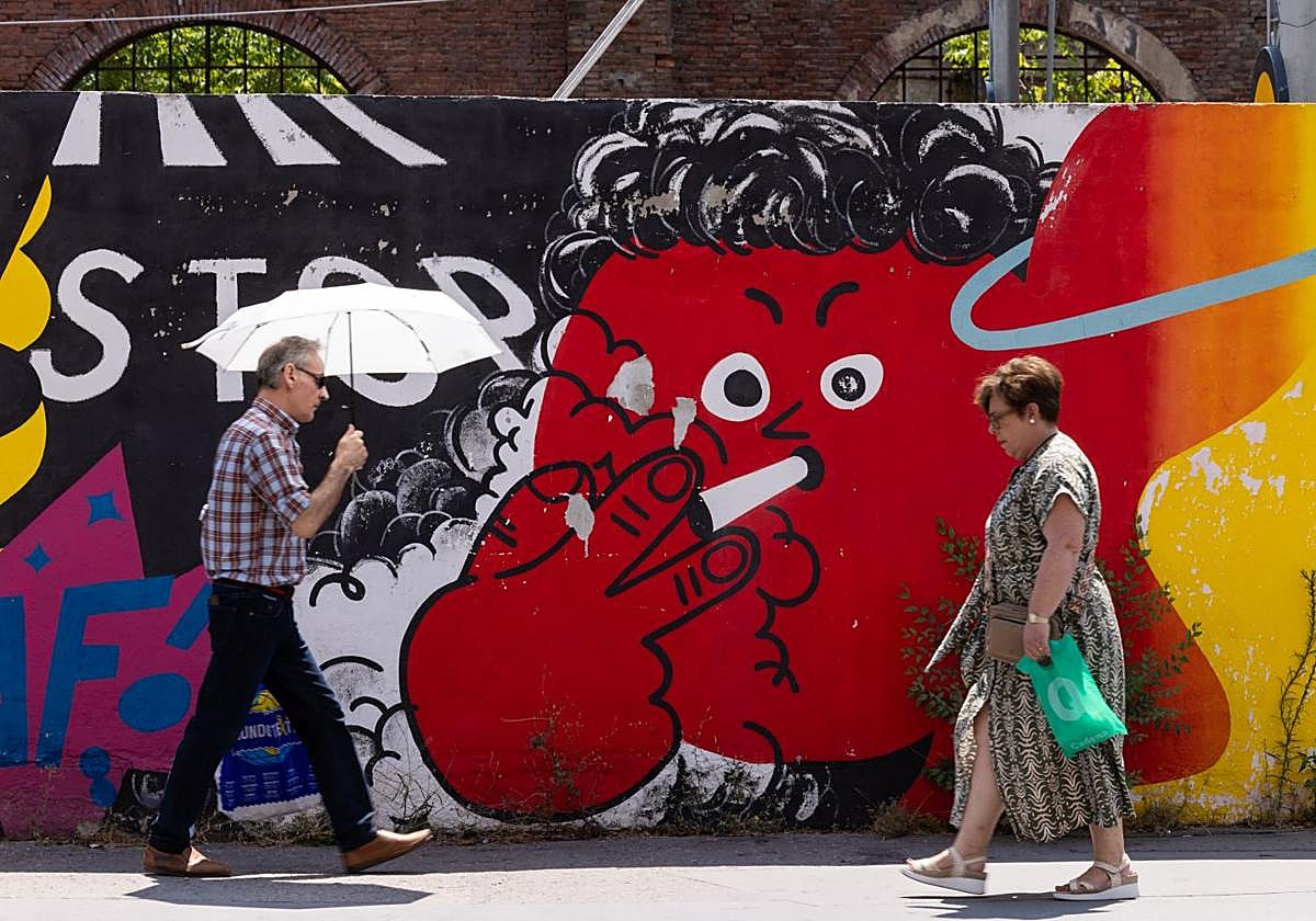 Un hombre se protege del sol con un paraguas en Valladolid.