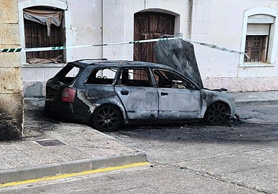 El coche calcinado en Población de Campos y la zona acordonada por la Guardia Civil.
