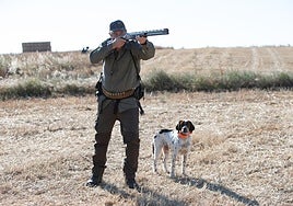 Un cazador, con su perro y su escopeta.