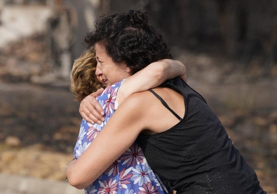 Dos vecinas de Las Médulas se abrazan y lloran ante la magnitud del desaste originado por el incendio.
