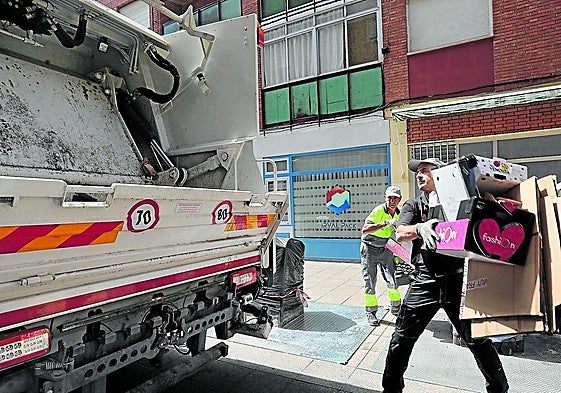 Los operarios retiran el cartón acumulado en la calle Mayor Antigua para depositarlo en el camión.