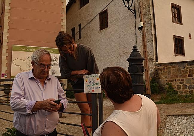 Vecinos de San Salvador de Cantamuda junto a un cartel dedicado a los bomberos «por todo vuestro esfuerzo».