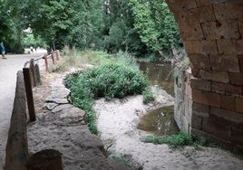 Arena acumulada en uno de los ojos del puente de San Marcos sobre el río Eresma.