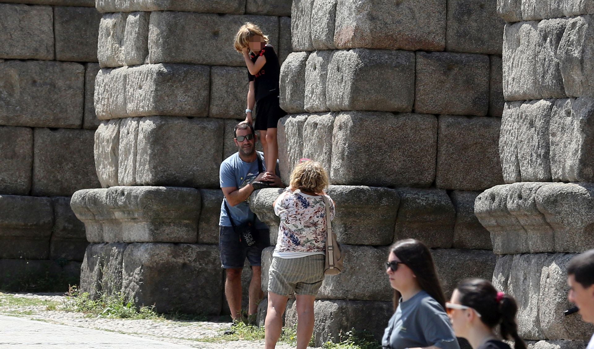 Un niño, subido a uno de los sillares del Acueducto de Segovia.