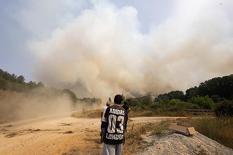 Vecinos de Calaveras de Arriba observan el fuego, que se ha reavivado este domingo.