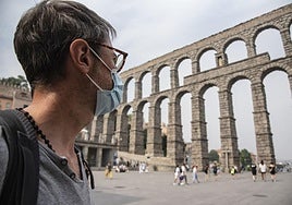 Un hombre con mascarilla cruza el Azoguejo.