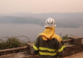 Un agente forestal observa el lago de Sanabria desde la localidad de San Martin de Castañeda.