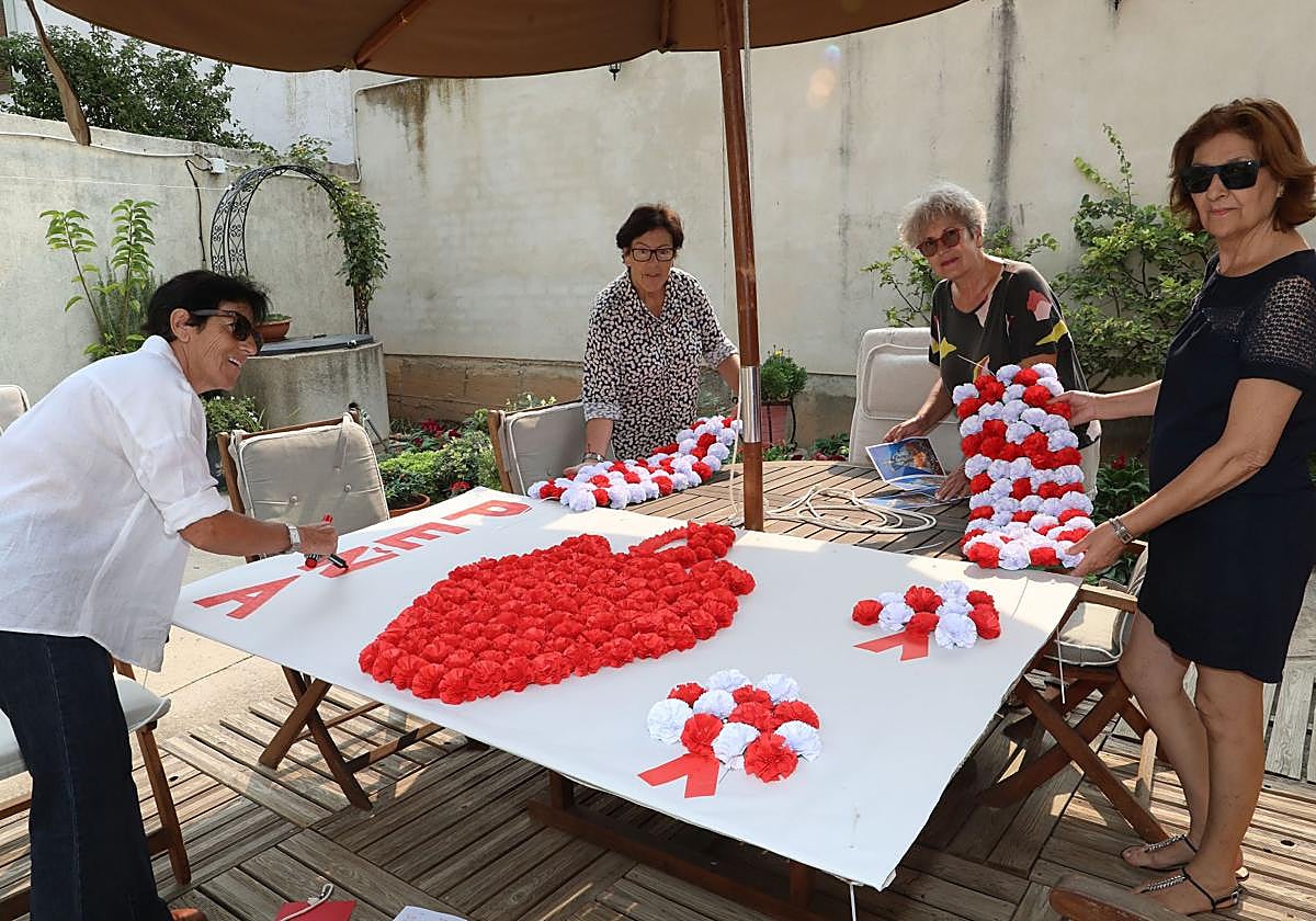 Pñistas de La Botijada preparan los adornos con los que agasajarán a la Virgen de Onecha.
