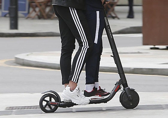 Dos personas en un patinete eléctrico, en imagen de archivo.
