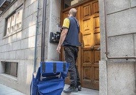Un cartero llama a un portal para entregar la correspondencia.
