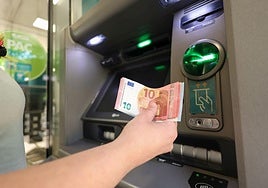 Un cliente saca dinero en un cajero automático.