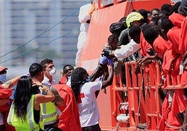 Un rescatista carga a un niño migrante mientras desembarca de un barco de la Guardia Costera española en el puerto de Arguineguín, en Gran Canaria.