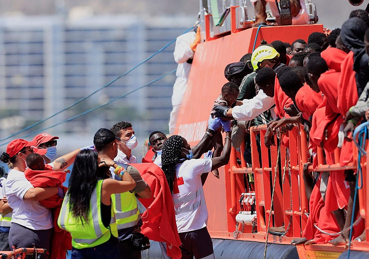 Un rescatista carga a un niño migrante mientras desembarca de un barco de la Guardia Costera española en el puerto de Arguineguín, en Gran Canaria.