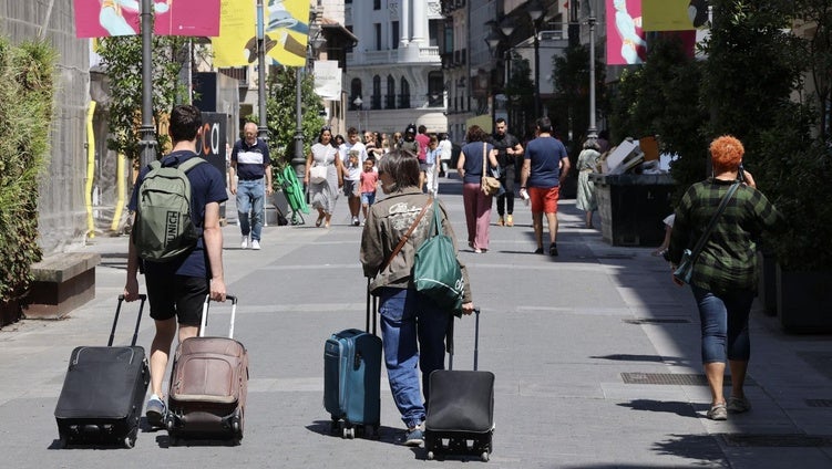 Viajeros con maletas por la calle Santiago, este mes de agosto.