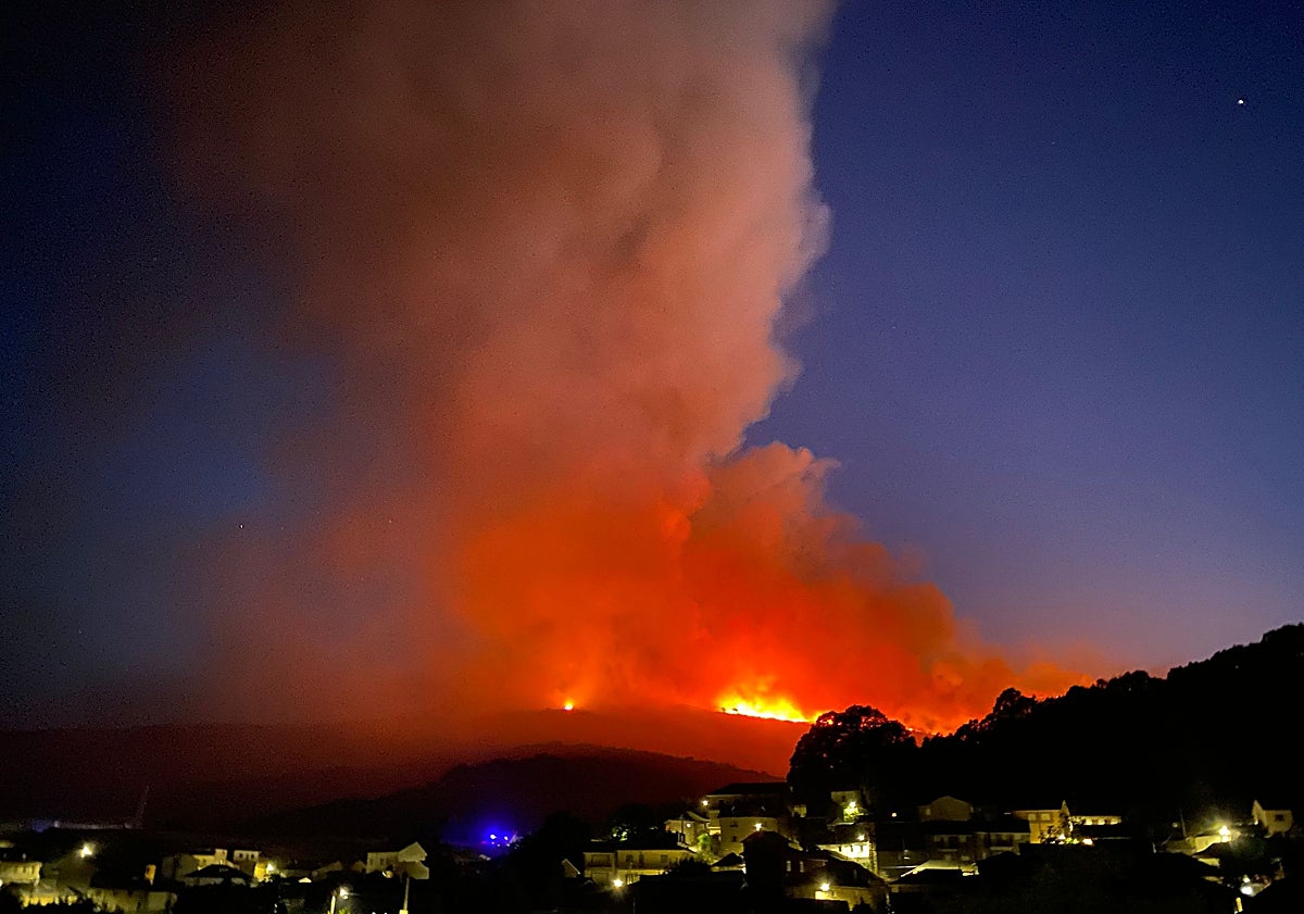Imagen principal - El fuego y el humo desde San Ciprián y vecinos del pueblo haciendo labores de desbroce.