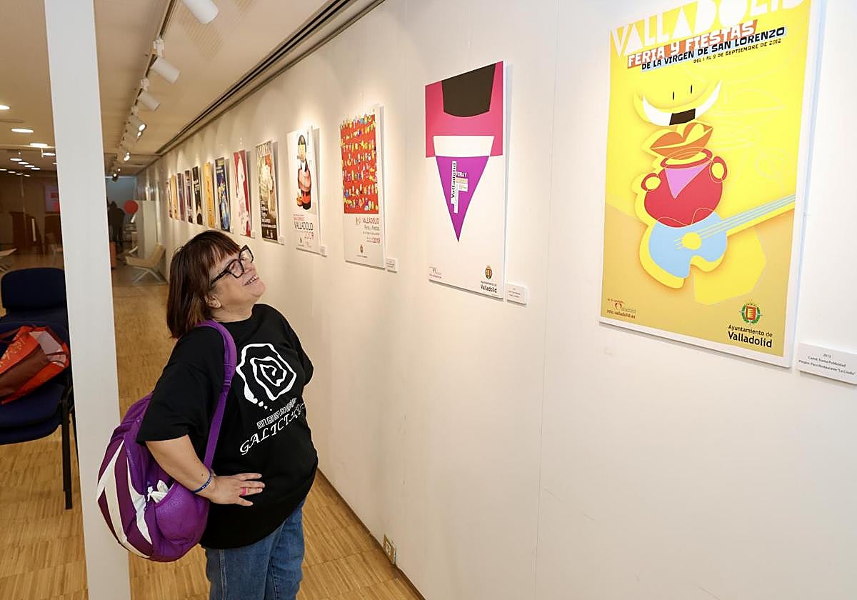 Una mujer se detiene a contemplar los carteles de 2011 y 2012.