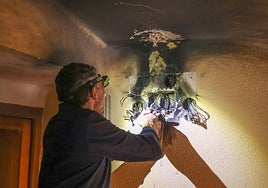El electricista José Antonio Ojeda, en plenas labores de reparación tras la explosión en una caja del número 11 de la calle Arzobispo García Goldaraz.