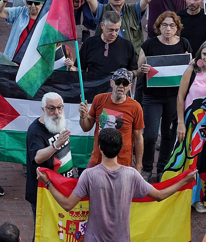 Imagen secundaria 2 - Unos jóvenes con la bandera de España recriminan a un grupo que reivindicaba una 'Palestina Libre' durante el pregón de las fiestas