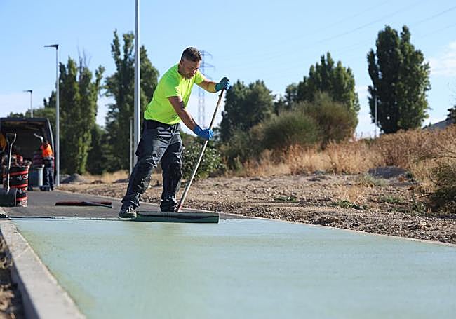 Un trabajador pinta el carril bici de la VA-20 a la altura de la carretera de Segovia.