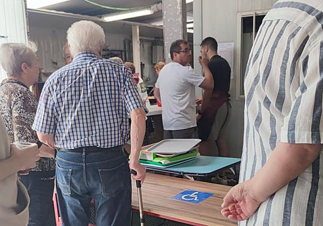 Un hombre espera en la zona prioritaria para personas con problemas de movilidad.