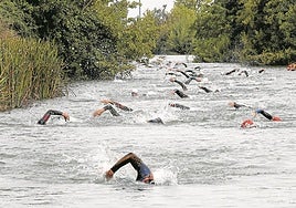 Los participantes en la prueba, durante el tramo de natación en aguas del Canal de Castilla.