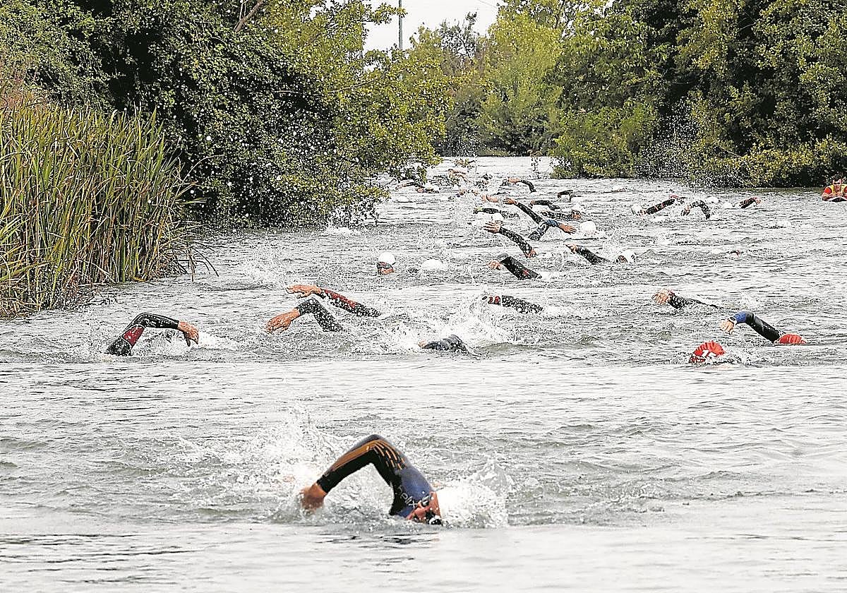 Los participantes en la prueba, durante el tramo de natación en aguas del Canal de Castilla.