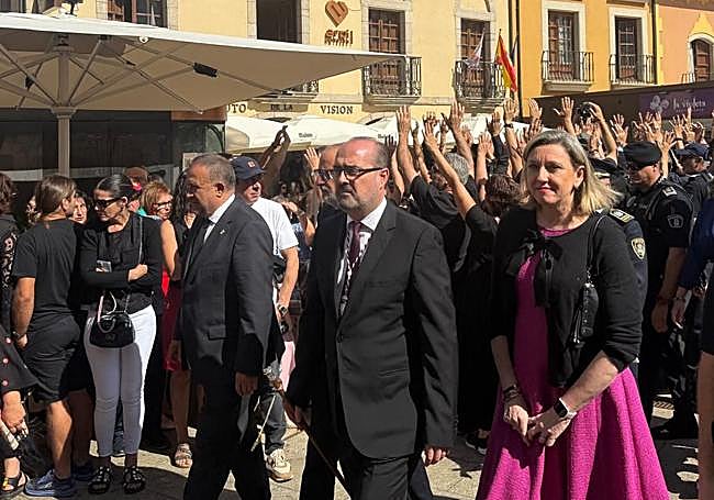 Las autoridades, durante el acto oficial mientras que los manifestantes les dan la espalda.