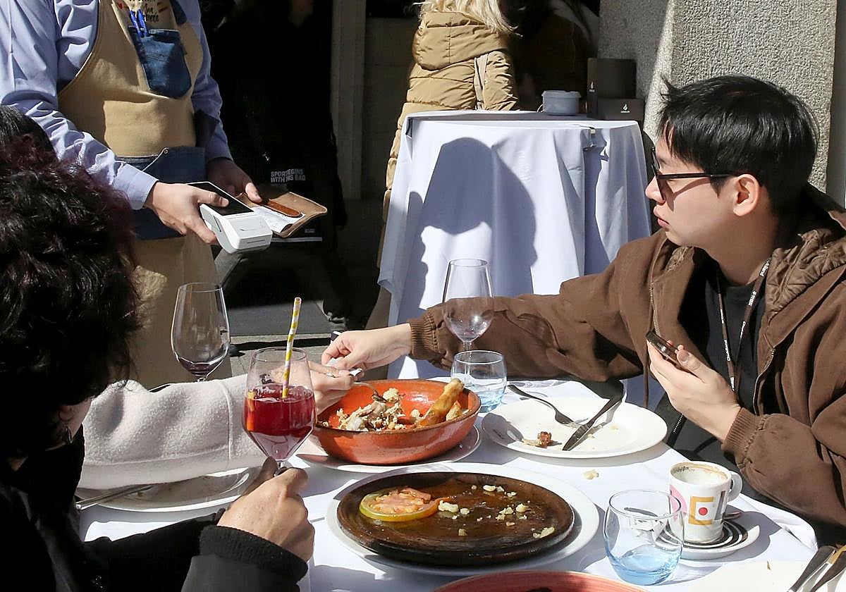 Un turista paga la cuenta tras almorzar en una terraza.