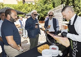 Algunos de los invitados esperando a degustar jamón durante el vermú