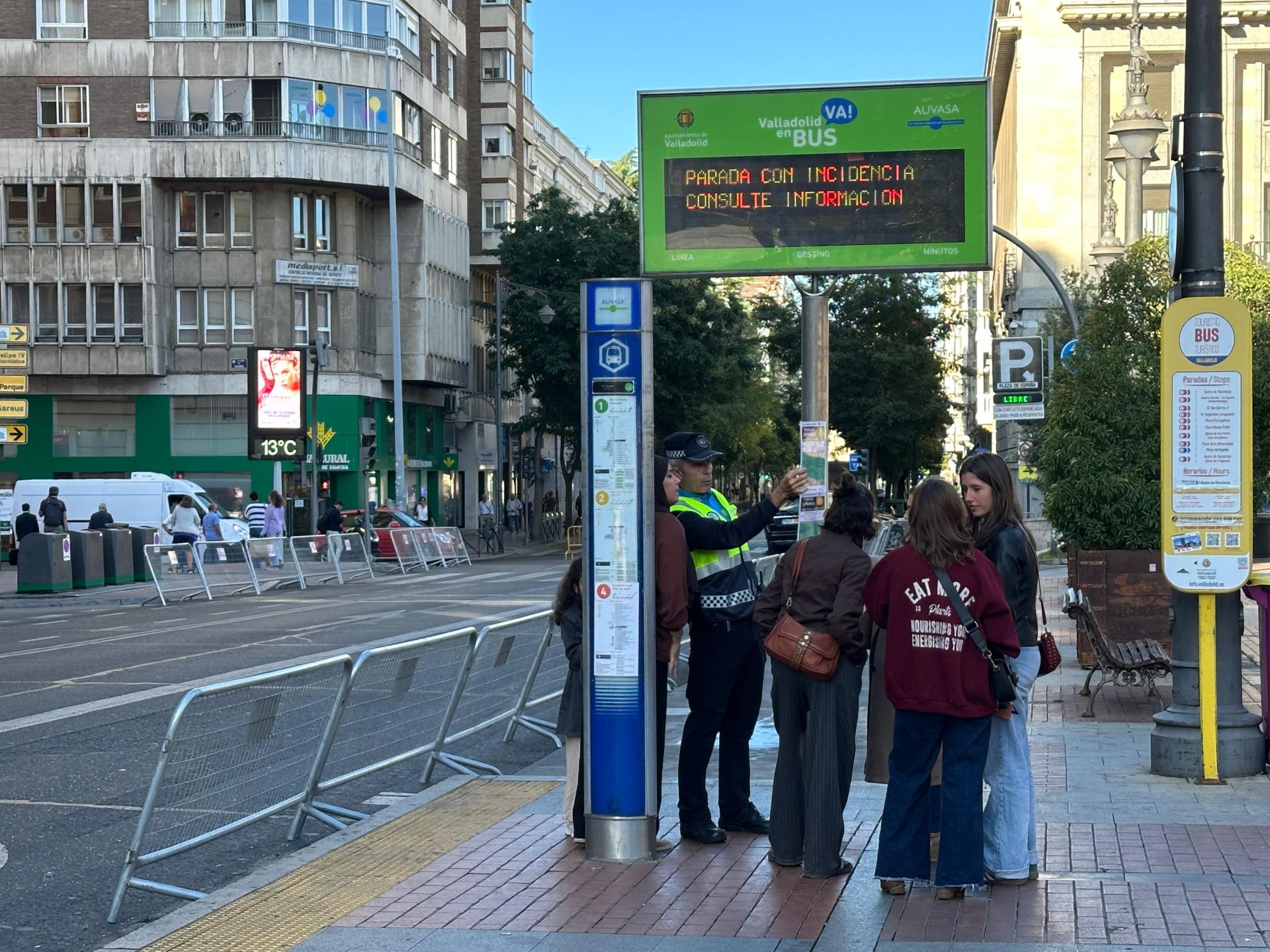 Un policía informa a varias personas en la plaza de España.