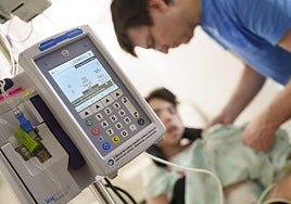 Un sanitario atiende a una niña en una unidad pediátrica de cuidados paliativos.