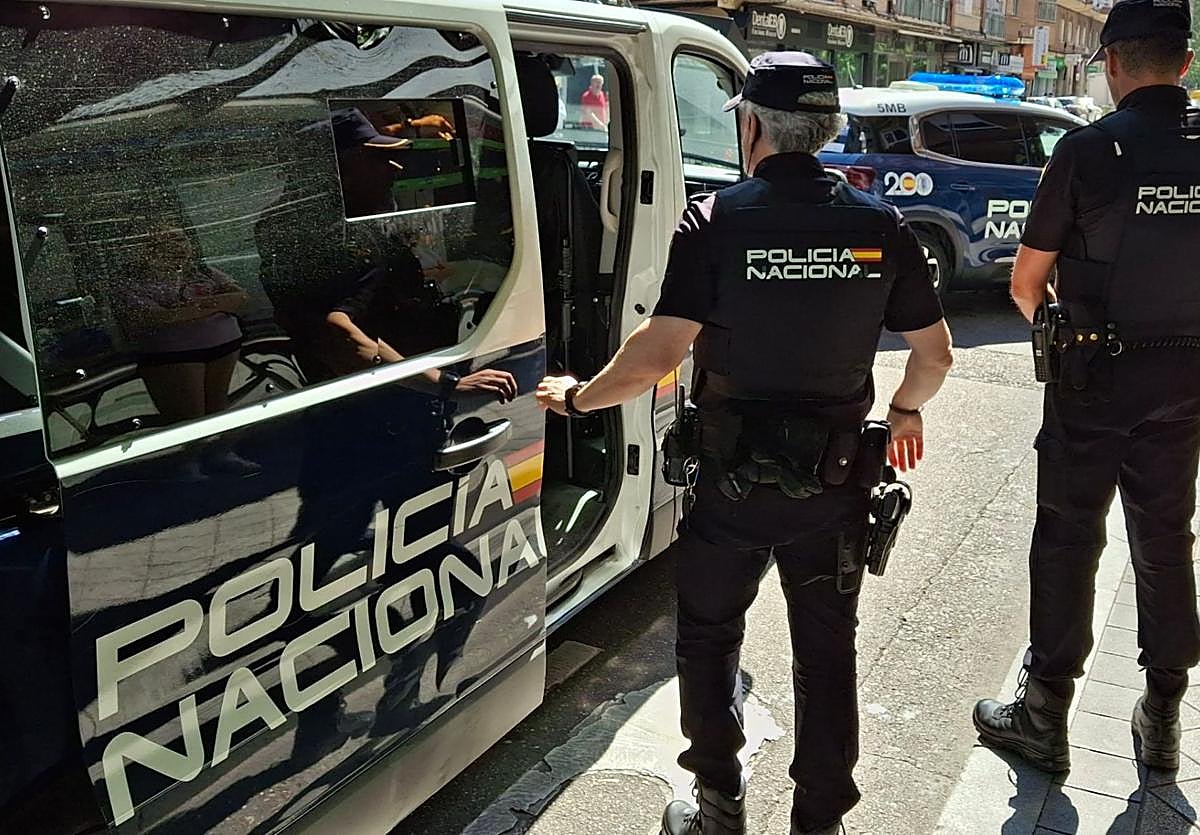 Dos agentes de la Policía Nacional junto a un furgón.