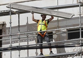 Un obrero de la construcción trabaja en un andamio.