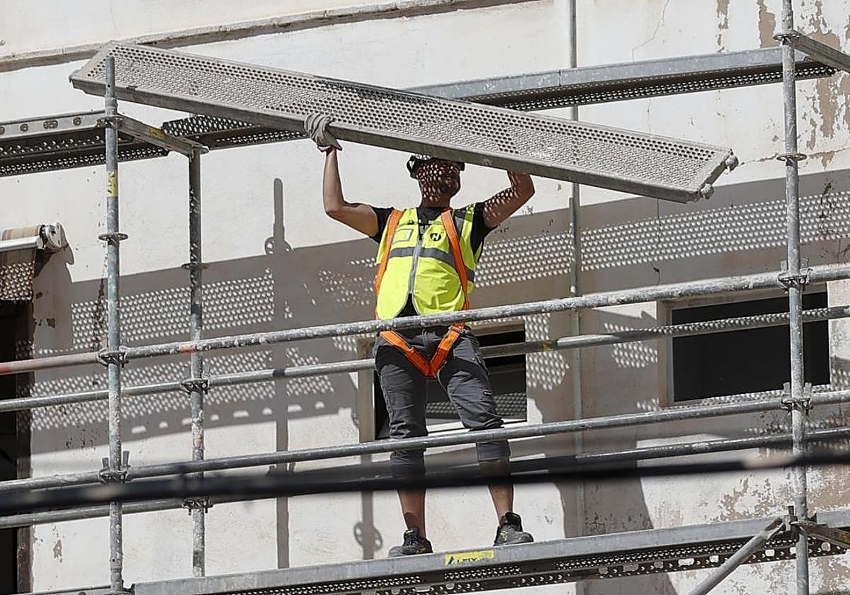 Un obrero de la construcción trabaja en un andamio.