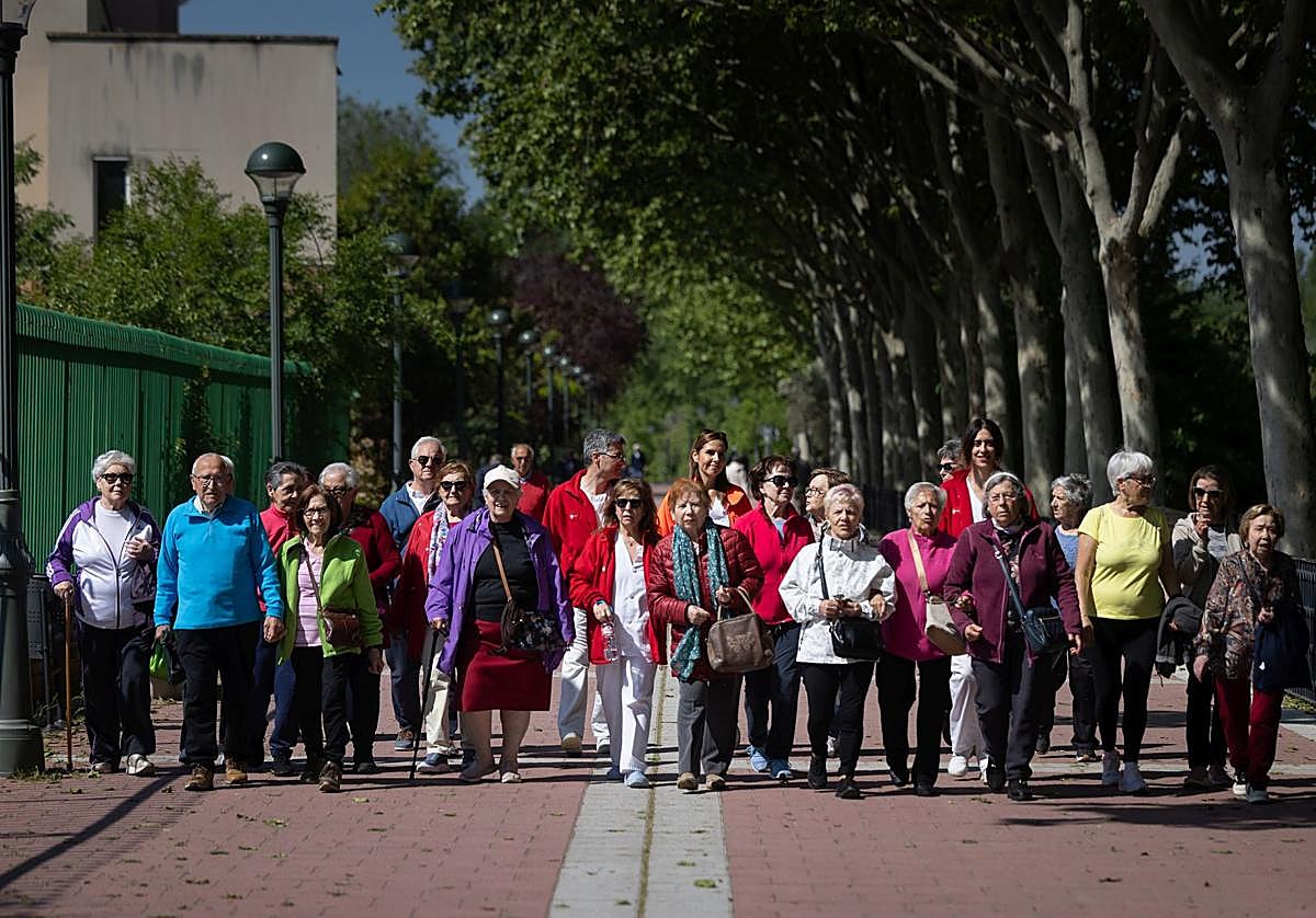 Vecinos de La Rondilla salen de paseo saludable por el barrio con sus enfermeros.