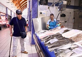 Un cliente camina junto a una pescadería del mercado de Delicias.
