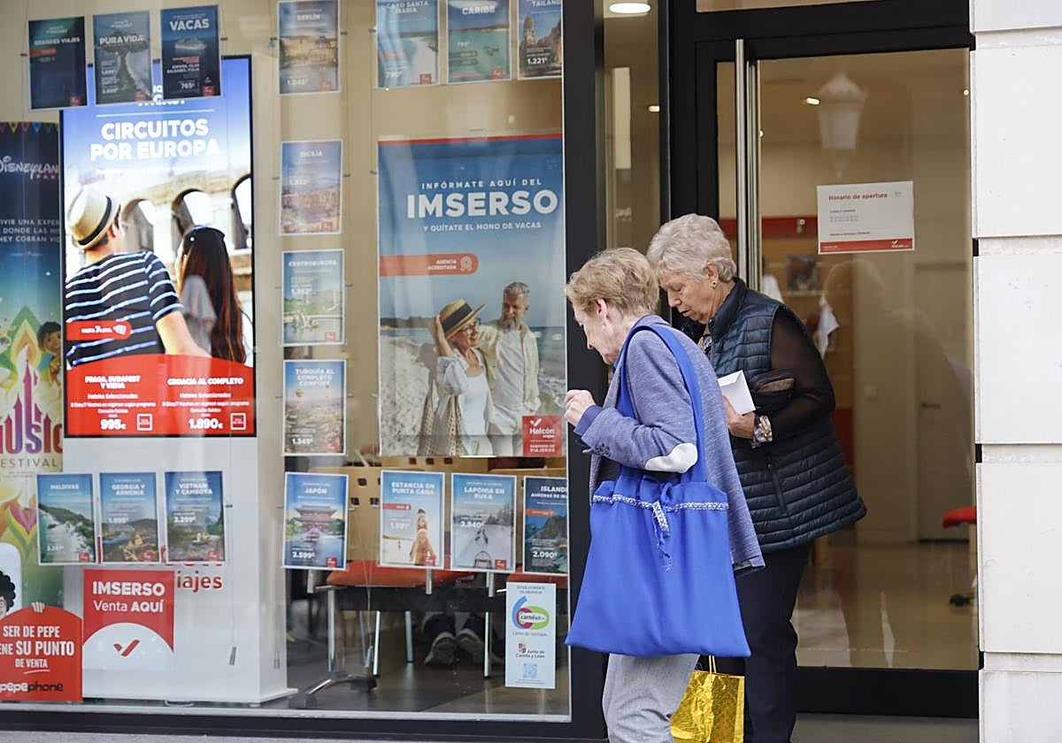 Dos mujeres salen este miércoles de una agencia de viajes en la capital palentina.