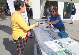 Mesa para inscripciones en la marcha en favor de las personas con daño cerebral adquirido colocada en confluencia de la calle Santiago con la plaza de Zorrilla.