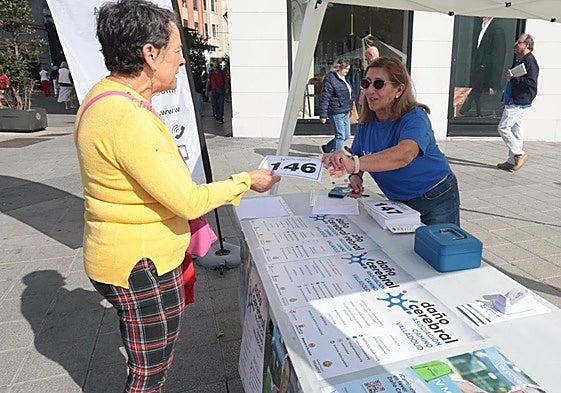 Mesa para inscripciones en la marcha en favor de las personas con daño cerebral adquirido colocada en confluencia de la calle Santiago con la plaza de Zorrilla.
