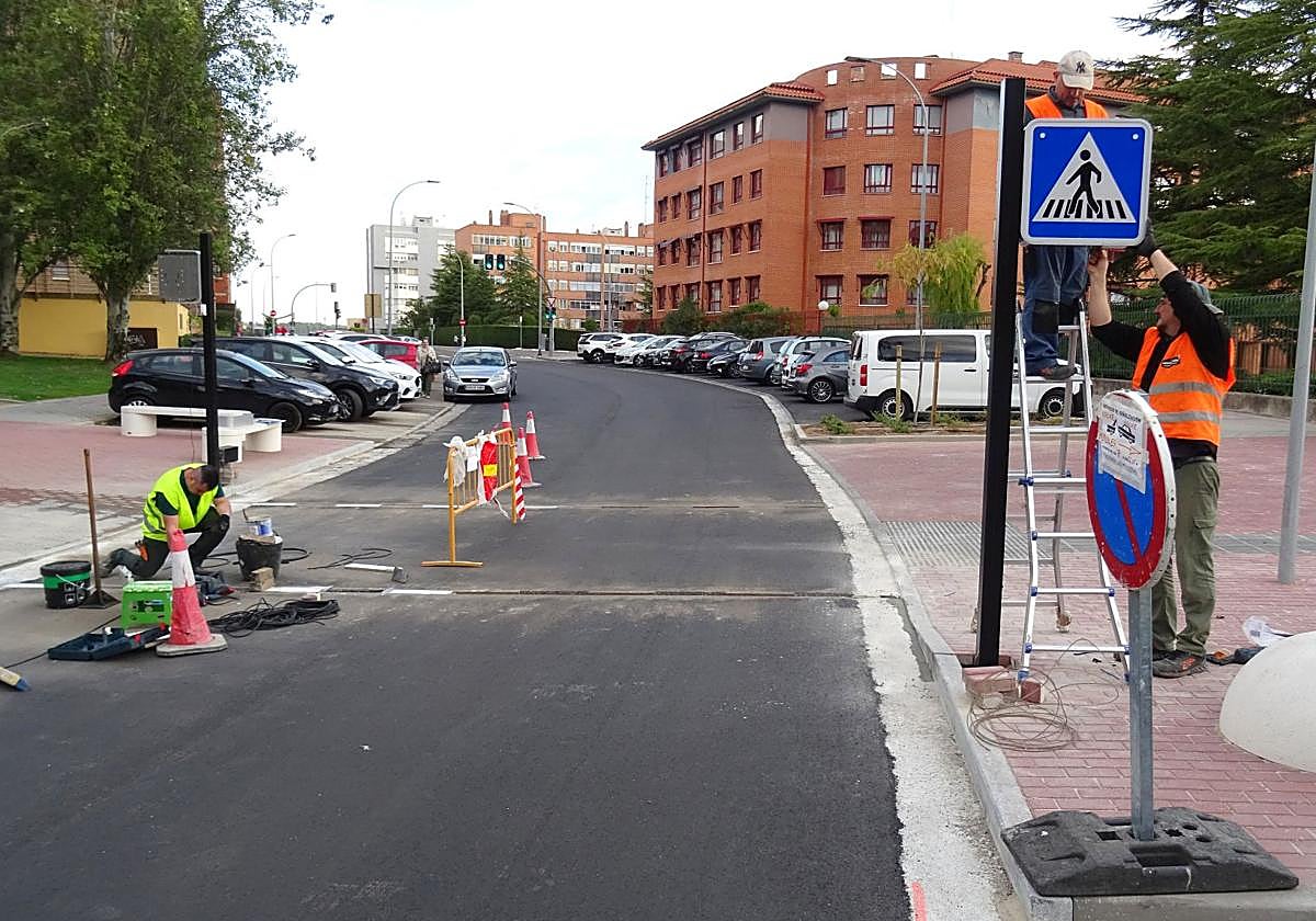Los operarios instalan la nueva señalización y colocan las tiras led en la calzada de la calle Manuel Silvela ante el colegio Tierno Galván.