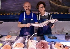 José Ignacio Pollino y Alicia Recio posan tras el mostrador de su pescadería del Campillo con una merluza.